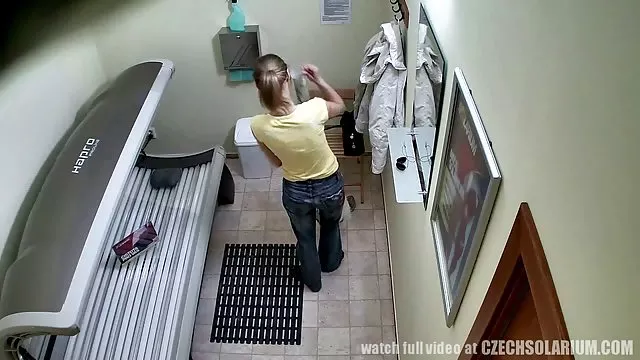 Meztelen csaj pihentető a tó mellett, egy horgászbottal a kezében